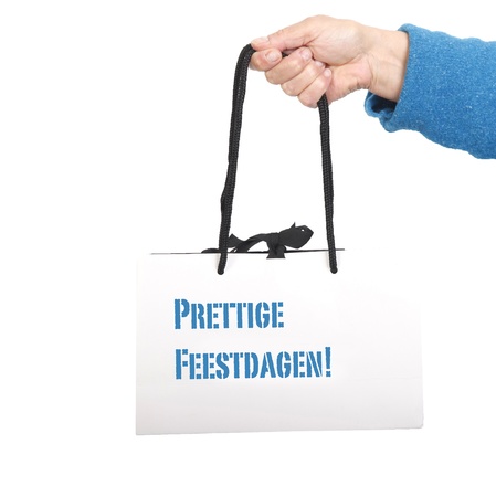 Hand in blue sweater holding white bag with black cord の写真素材