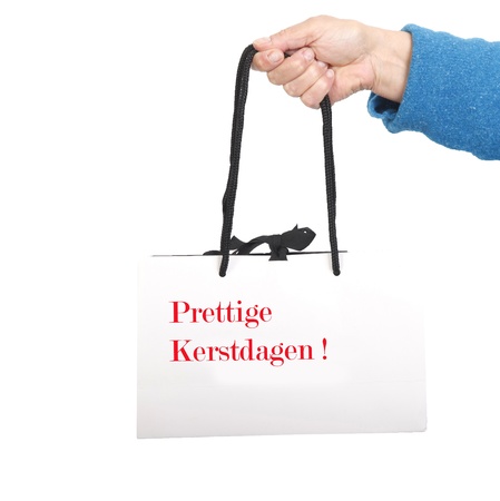 Hand in blue sweater holding white bag with black cord の写真素材