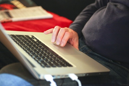 Hands of a male working on his laptop at homeの写真素材