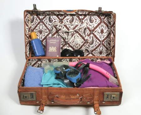 Open suitcase with beach items and passportの写真素材