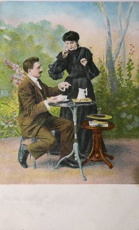 Loving couple drinking tea in garden surroundings - circa 1905 hand-tinted photograph postcard,のeditorial素材