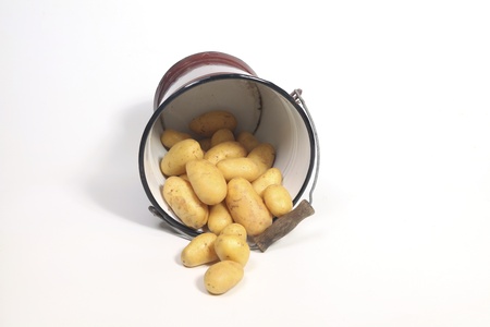 Potatoes falling out of a bucketの写真素材