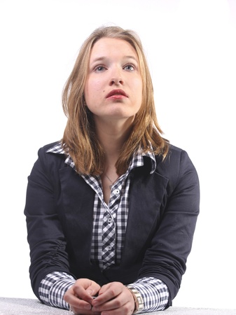 Young woman in business suit looking upwards intenselyの写真素材