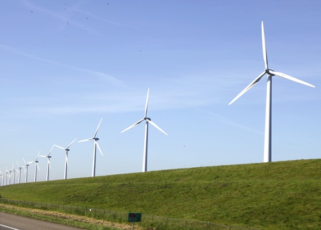 Windturbines on a dike in the Nertherlands near a motorway