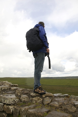 Hiker on the Hadrian wall in rain admiring the viewの写真素材