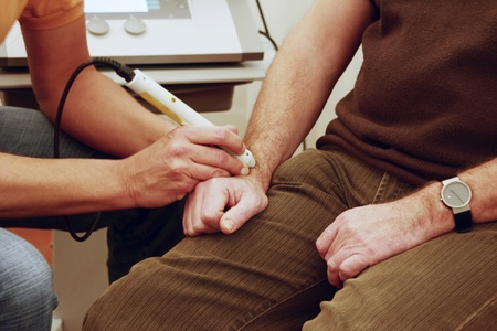 Physiotherapist treats patient with rsi on wrist with laser の写真素材