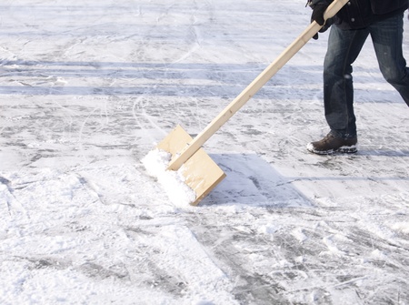 Shoveling snow with wooden shovel from ice for speed ice skating with wooden shovelの写真素材