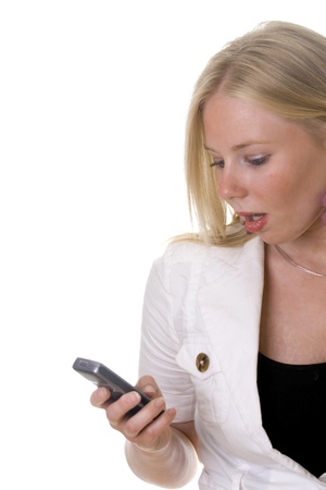 Attractive blonde woman looks surprised when she receives a text messsageの写真素材