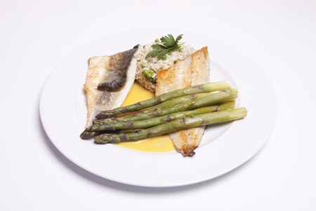 Delicious seabass in a  saffron sauce with  risotto and asparagus, の写真素材