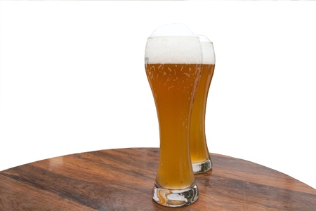 Two large glasses of weiss  white  German beer on a table 