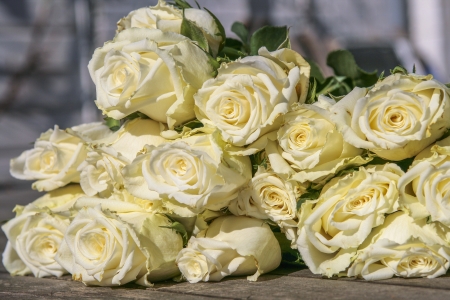 Bouquet of white roses on a grungy wooden tableの写真素材
