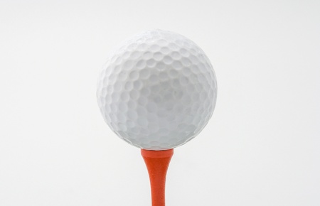 White golf ball on a red wooden teeの写真素材