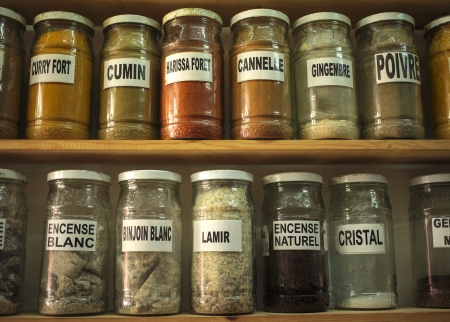 Glass jars in a moroccan shop with herbs, essences and minerals with french textの写真素材