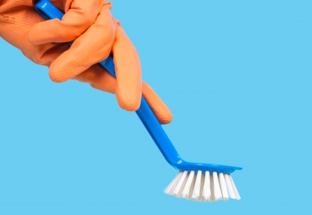 Hand with orange glove holding blue brush

の写真素材