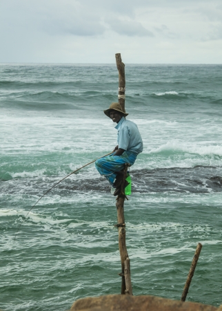 AHANGAMA, SRI LANKA - AUGUST 31  Unidentified man fishes by sitting on perches in water on August 31, 2013 in Ahangama, Sri Lanka  This type of fishing is traditional for South Sri Lanka のeditorial素材
