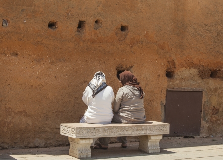 Two arab ladies chatting on a benchの写真素材