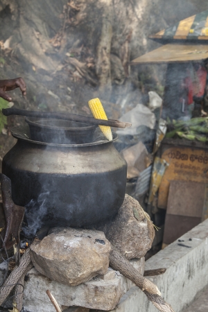 ELLA, SRI LANKA - AUGUST 27: Cooking and selling corn on the street in Sri Lanka. Street food cooking and selling is very popular among localsの写真素材
