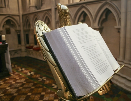 open bible on antique golden stand in medieval churchの写真素材