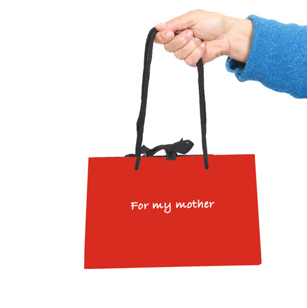 Hand in blue sweater holding red bag with text: for my motherの写真素材