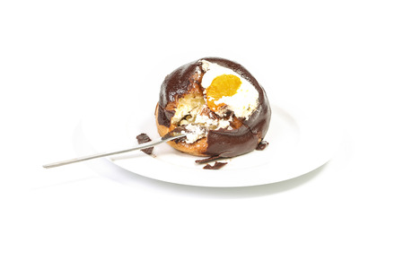 Bire of chocolate covered profiterole with whipped cream on a forkの写真素材