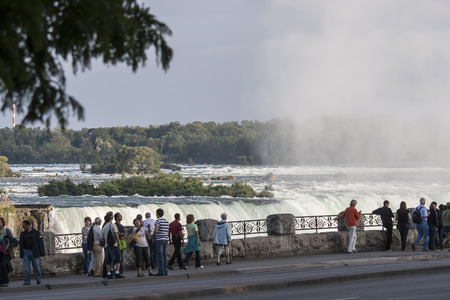 NIAGARA FALLS, CANADA -SEPT 6, 2008  Visitors walking by on the promenade of the Niagara Falls in Canada and experience the power and beauty of the fallsのeditorial素材