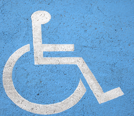 Blue square handicap sign with wheelchair painted on streetの写真素材