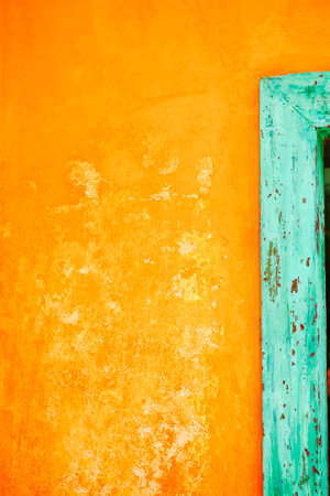 Yellow wall with green door in Greek villageの写真素材