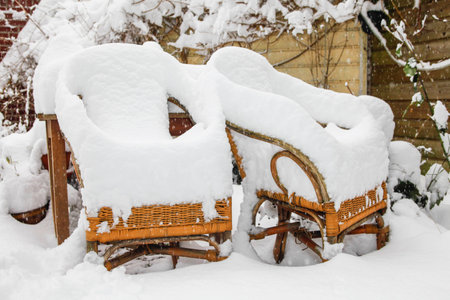 Two rotan garden chairs heavily covered with snowの写真素材