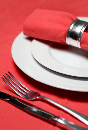 table setting with plates, napkin, silverware in a bright red colorの写真素材