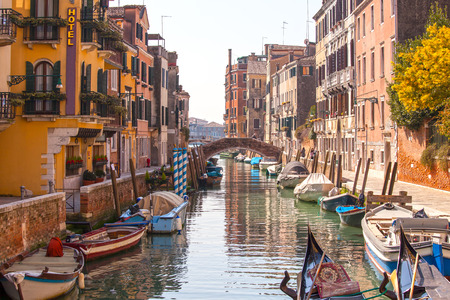 Beautiful canal with boats and a bridge in Venice, Italyのeditorial素材