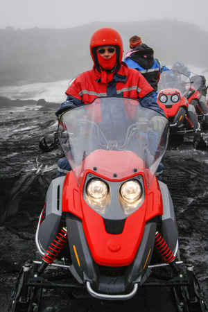 ICELAND-AUGUST 12  Man with red helmet and scarf on red snowmobile wearing sunglasses during a snowmobile tour on a glacier in Iceland on august 12, 2007  のeditorial素材