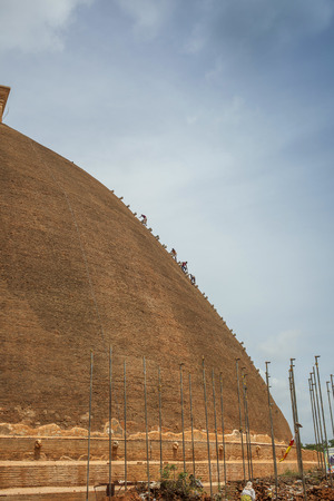 ANURADHAPURA, SRI LANKA- AUGUST 15, 2013  Workers descending a temple in Anuradhapura, Sri Lank during restoration workのeditorial素材