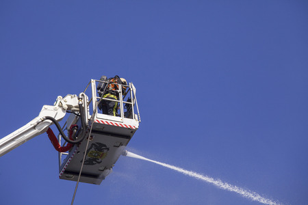 Fireman on an extended boom fighting a fire with a water hose

の写真素材