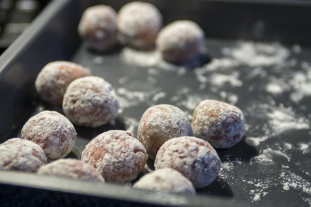 Prepared meatballs covered in flour in a trayの写真素材