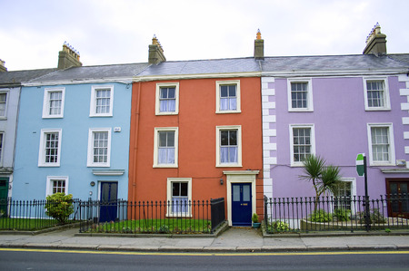 three victorian houses in orange, blue and lilac colors on a row on a Dublin streetのeditorial素材