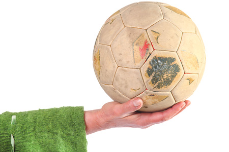 Woman holding old and weathered soccer ball in handの写真素材
