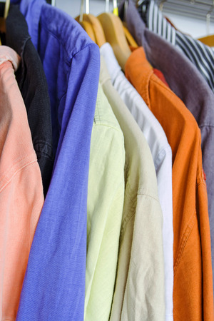 Shirts in closet on hanger in different colorsの写真素材