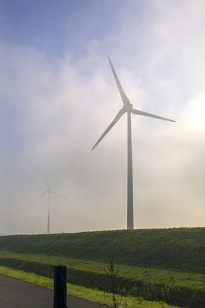 Windturbines on a dike in the fogの写真素材