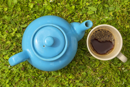 Blue teapot with cup filled with teaの写真素材