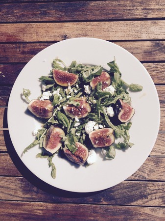 Delicious rocket salad with figs and goat cheese and honey and oilの写真素材