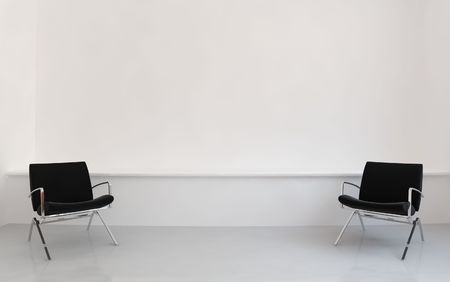 Two black Chairs to face a blank white wallの写真素材