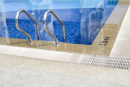 Close up shot of a blue color swimming pool with metal ladder.の写真素材