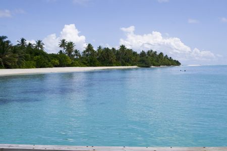 A wide shoot of a beach with clear transparent water in a island resort in maldives.の写真素材
