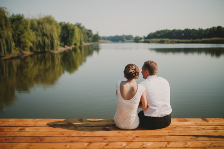 young couple sitting on a pierの写真素材