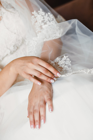hands of a bride on a white dressの写真素材
