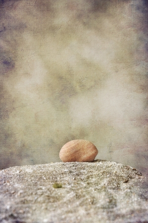 Single round stone on sand texturedの写真素材