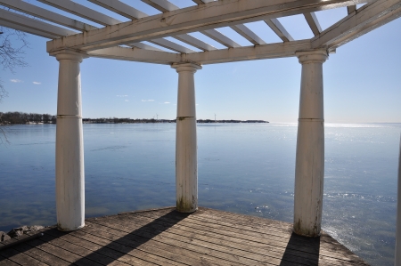 Sunset over blue sea with white pillars of a pier in the forground.の写真素材