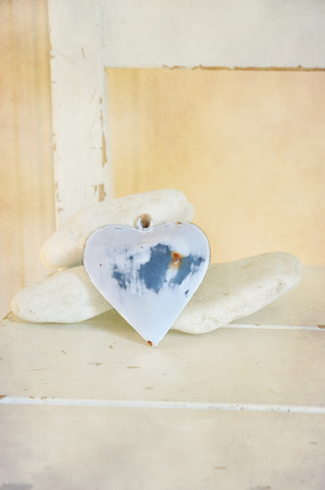 Heart in shabby chic among white stones の写真素材