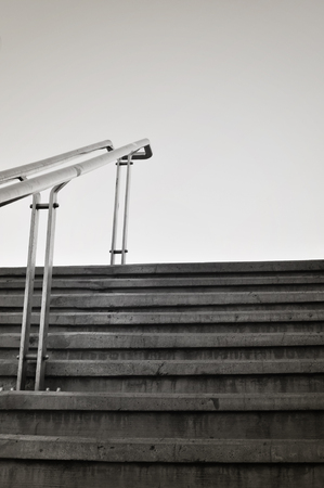 Cement steps with handrail in metal. Sparse composition against sky.の写真素材