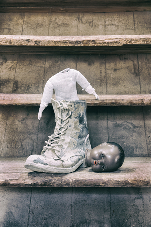 Old broken doll in boot with head next to it.の写真素材